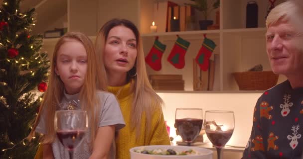 Groot familie diner avond aandachtig luistert naar Kerstmis verschillende generaties reünie grootmoeder grootvader ouders kleinkinderen — Stockvideo