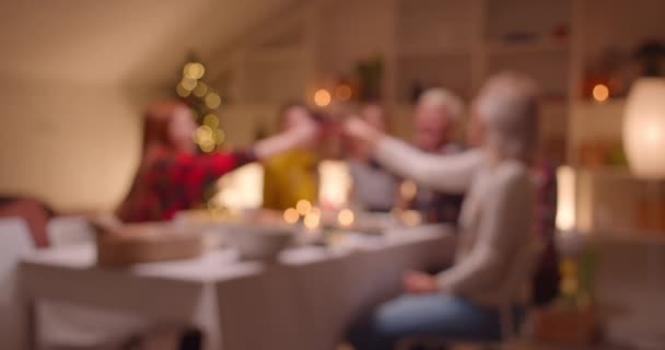 Verschwommene Defokussierung Große kaukasische Familie setzt sich an einen Weihnachtstisch Abendbrot Union Freude Lächeln Gespräch nach Hause Komfort — Stockvideo