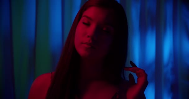 Retrato de uma jovem caucasiana neon escuridão azul fundo noite sombra vermelho luz goza — Vídeo de Stock
