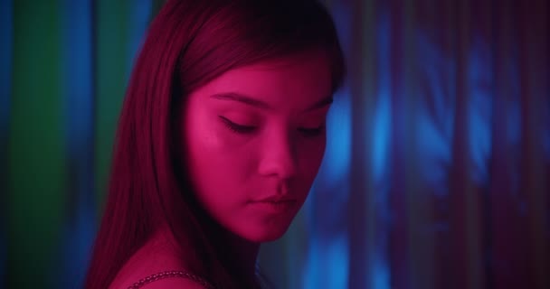 Close-up dziewczyna portret różowe światło neon moda radość flirt niebieski skromne tło — Wideo stockowe