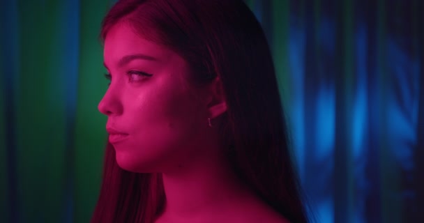 Close-up dívka portrét růžové světlo neon módní radost pohled profil flirt smutek modré pozadí skromný — Stock video