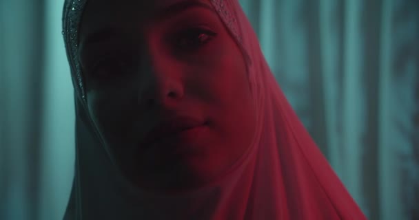 Närbild Vackert porträtt säker porträttflicka i vit hijab profil neon tropisk bakgrund sensuell make-up porträtt röd ljusstråle skugga silhuett — Stockvideo