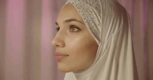 Porträt kaukasischen selbstbewusst Porträt Mädchen im weißen Hijab Tageslicht Creme Hintergrund Glanz Make-up zuversichtlich Blick nach oben Glanz Profil — Stockvideo