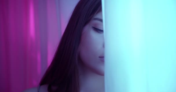 Närbild porträtt av en kaukasisk flicka neon ljus gardin mode modell ömhet frestelse flirt — Stockvideo