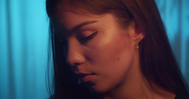 Close-up Kaukasisch jong meisje portret glimlach flirten blauw achtergrond — Stockvideo