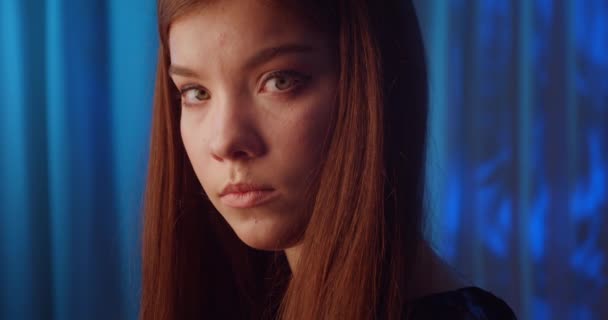 Nahaufnahme traurige kaukasische junge Mädchen Porträt Sehnsucht Blick blauer Hintergrund — Stockvideo