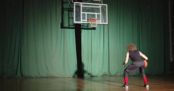 Basketbal hráč kudrnaté podívá na koš drží míč připravuje sebevědomí sám stín jasný paprsek trénink hrát zelené pozadí — Stock video