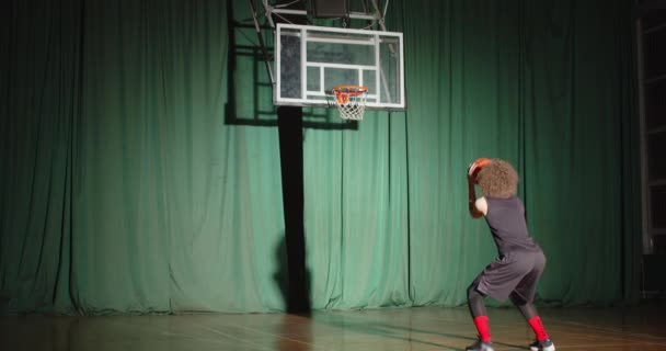 Кучерявый баскетболист смотрит на корзину держит мяч готовит уверенность бросает мяч счет зеленый фон — стоковое видео