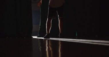 Genç beyaz basketbolcu topu parmağında döndürmeye hazırlanıyor. Parlak ışık. Gölge. Kandırmaca. Profesyonel top sürme. Antrenman. Arka plan.