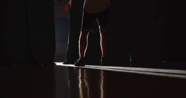 Junger kaukasischer Basketballspieler bereitet sich darauf vor, den Ball am Finger zu drehen. Helles Licht. Schatten. Trick. Professionelles Dribbling. Ausbildung. Rückseite. — Stockvideo