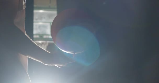 Gros plan Jeune joueur de basket-ball caucasien se préparant à faire tourner la balle sur son doigt lumière vive ombre truc professionnel — Video