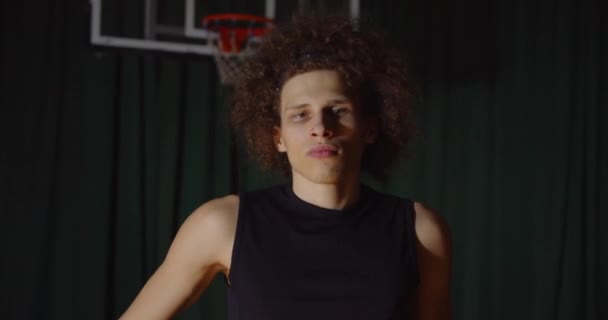 Populära lockigt hår kaukasiska basketspelare porträtt allvarlig titt på kameran — Stockvideo
