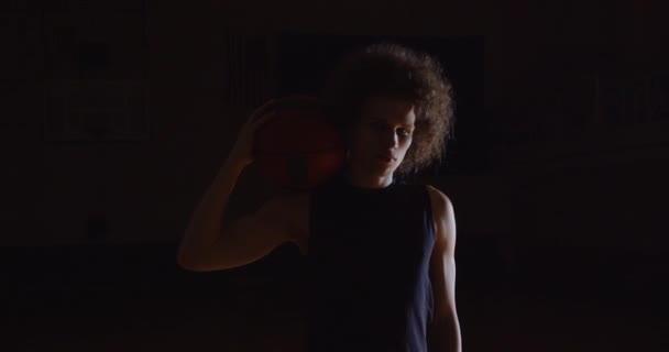 Populaire bouclé joueur de basket-ball caucasien portrait regard sérieux à la caméra photographes flash détient balle professionnelle — Video