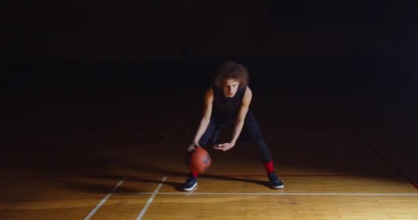 Curly Caucasiano Basquetebol Jogador Dribbling Ball Camera Profissional Darkness Ray Of Light — Vídeo de Stock