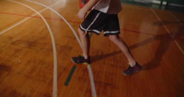 Jonge professionele basketbalspeler gooit de bal in de mand nacht duisternis silhouet achteraanzicht dribbelen close-up parket uithoudingsvermogen — Stockvideo