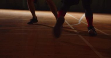 İki genç basketbolcu basketbol oynuyor amatörler salon spor parkesi sürüyorlar.