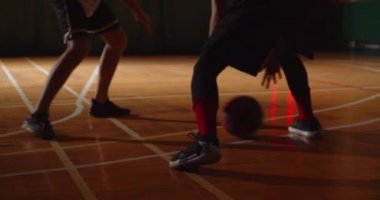 İki genç basketbolcu basketbol oynuyor amatörler salon spor parkesi sürüyorlar.
