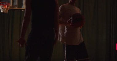 İki genç basketbolcu basketbol oynuyor amatörler salon spor parketi, dayanıklılık akıyor.