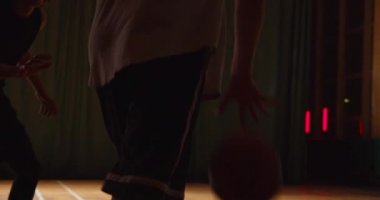 İki genç basketbolcu basketbol oynuyor amatörler salon spor parketi dayanıklı gece oyunu