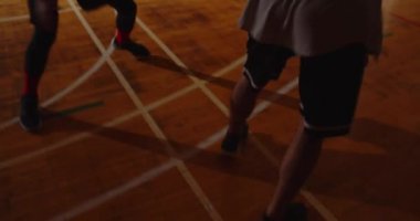 Yakın plan iki genç basketbolcu basketbol oynuyor amatörler salon spor parkesi ve dayanıklı gece oyunu.