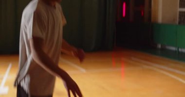 İki genç basketbolcu basketbol oynuyor amatörler salon spor parketi siluetleri rakip savunma bloğunun gece maçında top sürüyor.