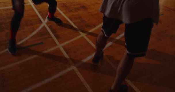 Close-up Dos jóvenes jugadores de baloncesto jugando basket ball competición aficionados sala deportes parquet dribleando resistencia noche juego — Vídeo de stock