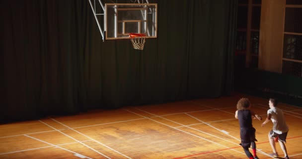 Vista superior de dos jugadores de baloncesto rizado driblando confrontación juego de noche — Vídeos de Stock