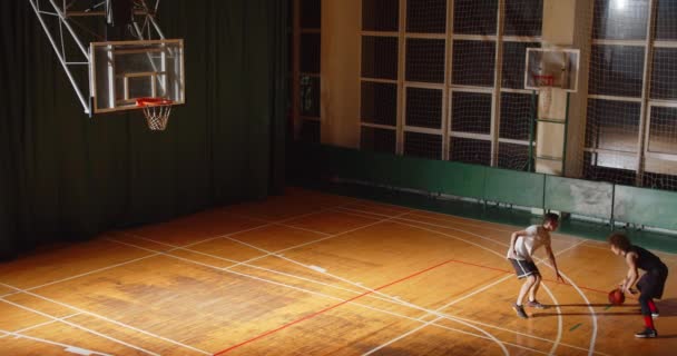 Vista superior de dos jugadores de baloncesto rizado driblando juego nocturno enfrentamiento ataque defensa tres puntos — Vídeos de Stock