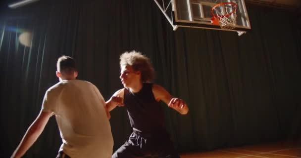 Крупный план противостояния двух баскетболистов спорта выносливость нападение обороны ночного спортивного зала корзины — стоковое видео