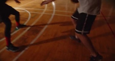 Yakın çekimde basketbol maçı. İki adam güreş tutuşu. Akşam antrenmanı.