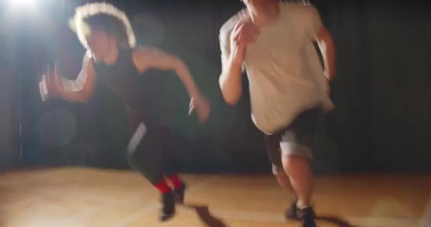 Två unga pojkar basket spelare shuttle race bankett hall kväll natt ray av ljus träning uthållighet — Stockvideo