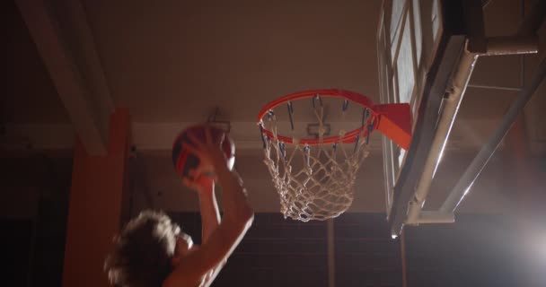 Close-up mand basketbal bal bal slam punk krullend blank speler springen straal van licht — Stockvideo