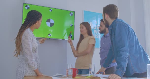 Čtyři různí multiraciální kolegové v kancelářské chromakey prezentace diskuse plánování vtipkování smích — Stock video
