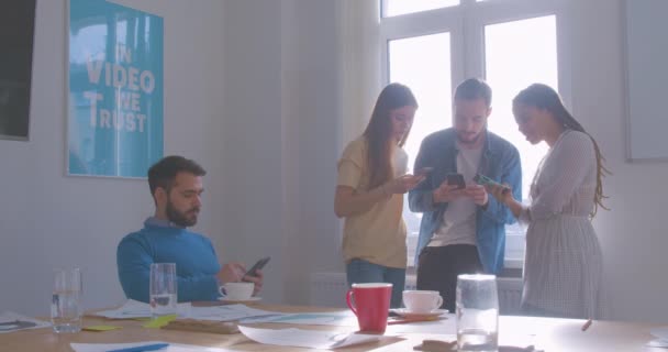 Cuatro diversos colegas multirraciales en el café de la oficina utilizan teléfono inteligente moderno problema de Internet — Vídeos de Stock