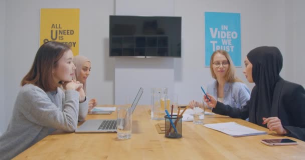 Четыре различных работы в офисе хромаки бумажный бизнес девушки диаграммы коворкинг спор женщины хиджаб успешным — стоковое видео