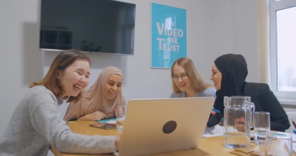 Olika kvinnliga kollegor på kontoret hijab asiatisk förhandling diskussion titta på rolig video — Stockvideo