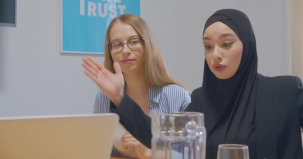 Diversas colegas femeninos en la oficina conversaciones discusión hijab asiático sonrisa riendo chistes — Vídeos de Stock