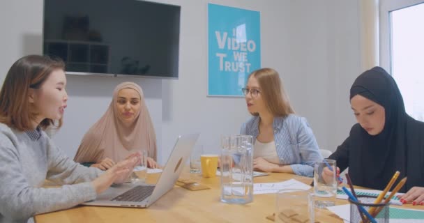 Diverse female colleagues at office talks discussion hijab asian business plan idea woman smile laugh — Stock Video