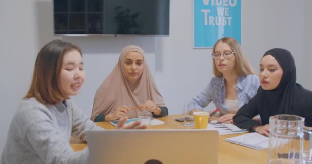 Четыре уверенные в себе коллеги обсуждают хиджаб в офисе — стоковое видео