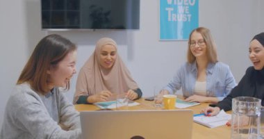 Dört kendine güvenen, neşeli iş arkadaşı ofis kadınları tesettür iş planı gülüşü