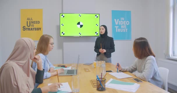 Quatre confiants joyeux divers collègues bureau femmes hijab discussion business plan présentation chromakey sérieux 