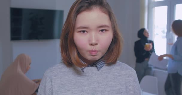 뒤에 있는 젊고 진지 한 아시아인 사무실 여자의 모습 — 비디오