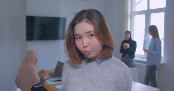 Portrait of a young beautiful shy modest asian office girl on the background — Stok Video