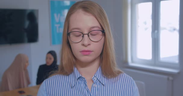 Portrait d'une jeune belle triste enlève lunettes caucasienne blonde fond de bureau — Video