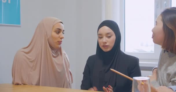 Drei Büro-Kommunikationspause Kollegen verwenden ein Smartphone verschiedene Rassen fröhlichen Witz Hijab asiatisch — Stockvideo
