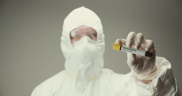 Wetenschapper laboratorium bescherming glazen reageerbuis concept coronavirus bloed grijze achtergrond — Stockvideo