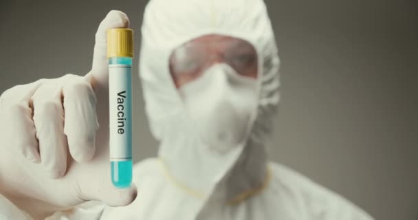 Wetenschapper laboratorium bescherming glazen reageerbuis concept vaccin geneeskunde bloed grijze achtergrond — Stockvideo