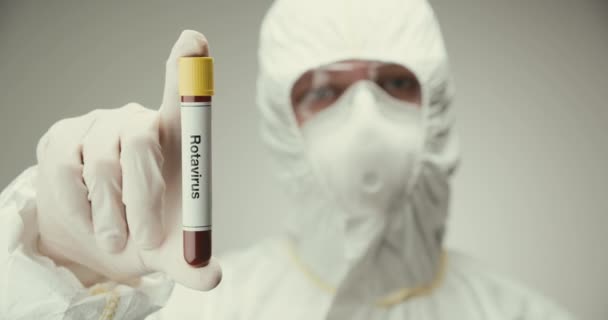 Científico gafas de protección de laboratorio concepto de tubo de ensayo Rotavirus sangre gris fondo — Vídeos de Stock