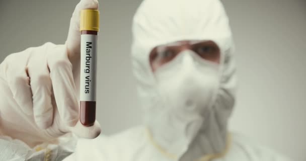 Conceito de tubo de teste de óculos de proteção de laboratório cientista Marburg vírus sangue fundo cinza — Vídeo de Stock