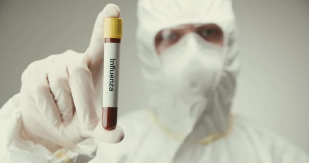 Científico gafas de protección de laboratorio concepto de tubo de ensayo Influenza virus sangre gris fondo — Vídeos de Stock